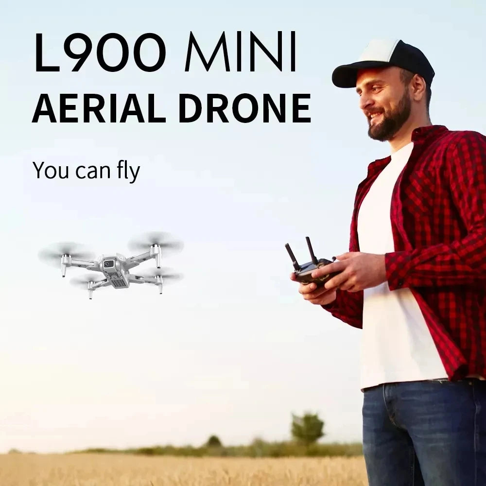 Man holding a drone controller with text 'L900 MINI AERIAL DRONE You can fly' on a blurred outdoor background.