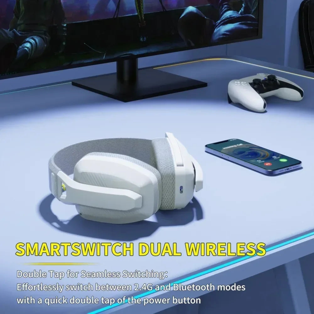 White gaming headset on a desk with a monitor, controller, and phone in the background.