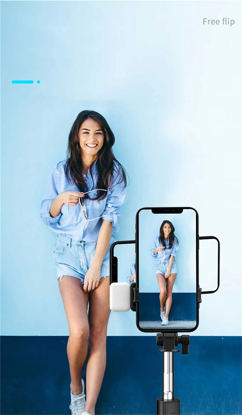 Woman using a smartphone with a selfie stick against a blue background