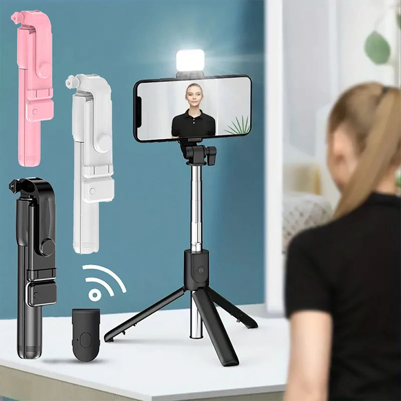 Smartphone with a selfie stick and light on a stand, with a person using the setup.