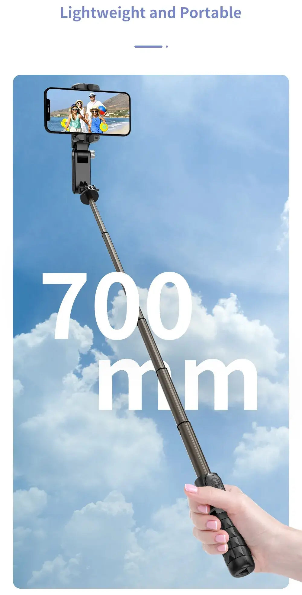 Hand holding a selfie stick with a smartphone, extending to 700 mm, against a blue sky background.