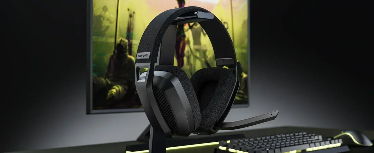 Gaming headset on a desk with a computer monitor displaying a game in the background