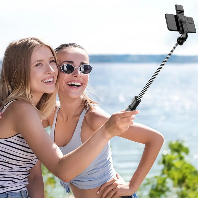 Two women taking a selfie with a monopod on the beach