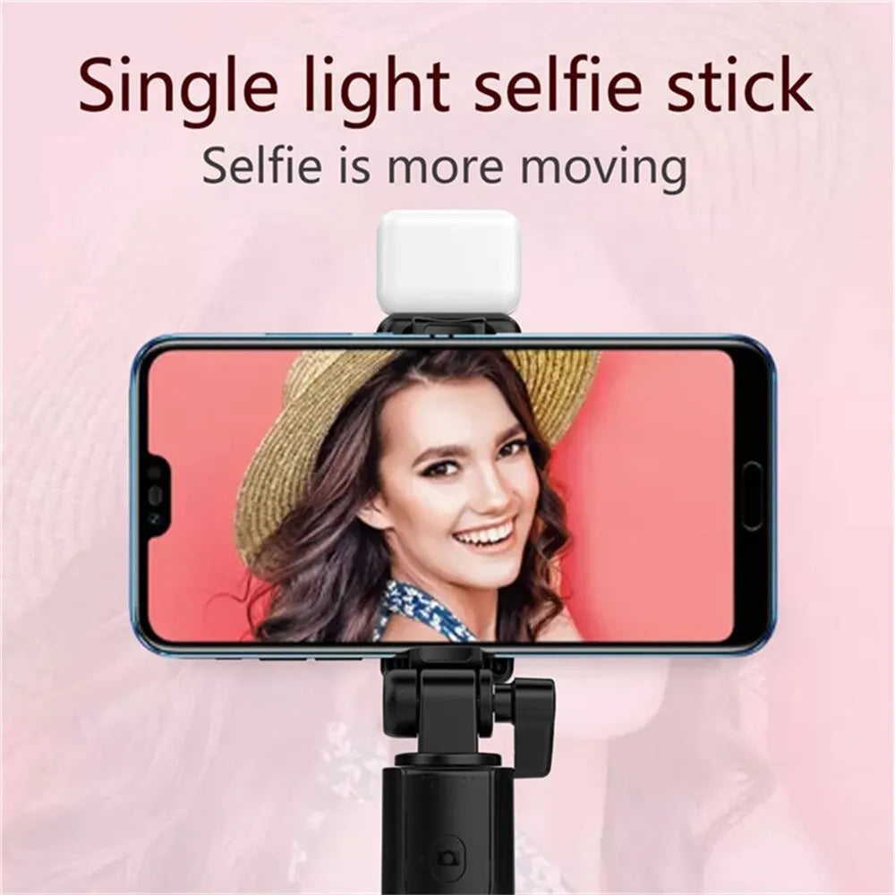 Smartphone with a selfie stick attachment on a pink background