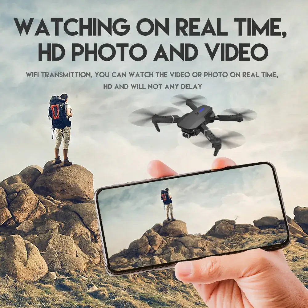 Person on a mountain top with an E88 Pro drone and smartphone displaying real-time video feed
