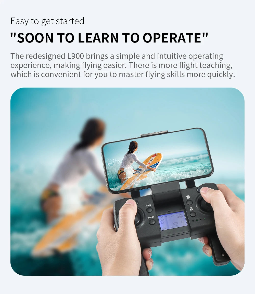 Person holding a remote control with a screen displaying an image of two people on a beach, with text about the L900 drone.