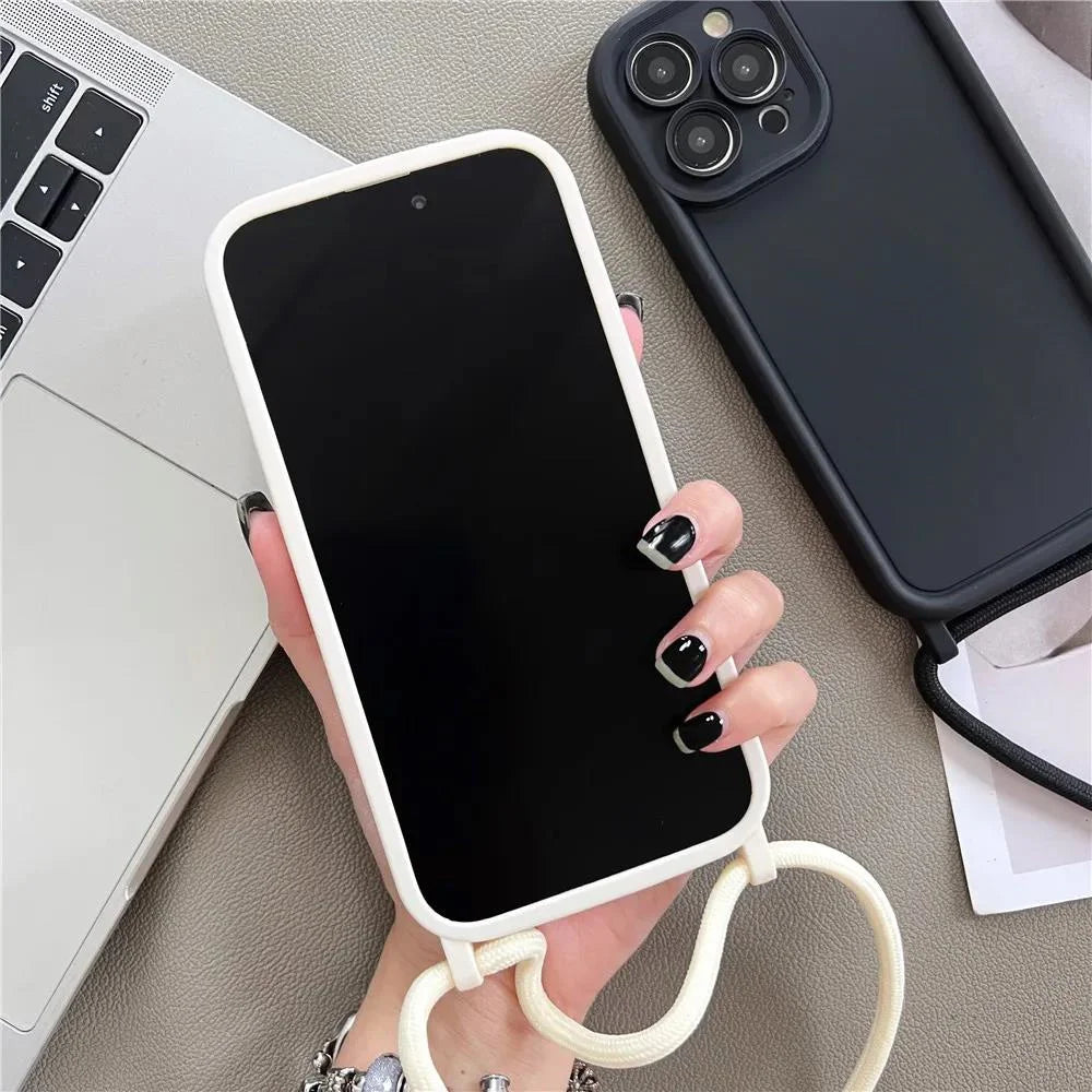 Person holding a phone with a white case on a desk with a laptop and another phone.