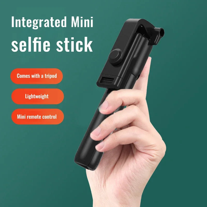 Hand holding a black integrated mini selfie stick with features listed on a green background