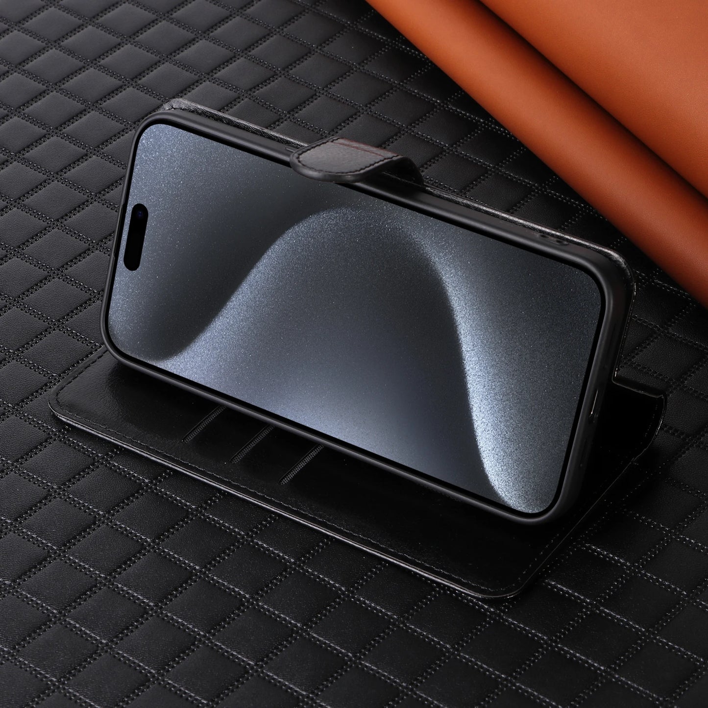 Black phone case on a textured black surface with a brown object partially visible.