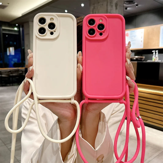 Two phone cases, one white and one pink, held by a person with straps.