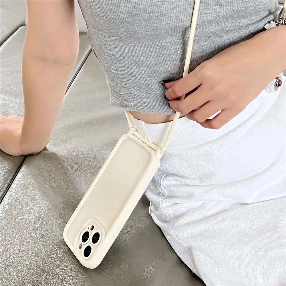 Phone case with a strap held by a person on a light gray surface