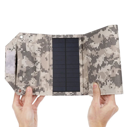 Camouflage-patterned solar panel held by hands on a white background