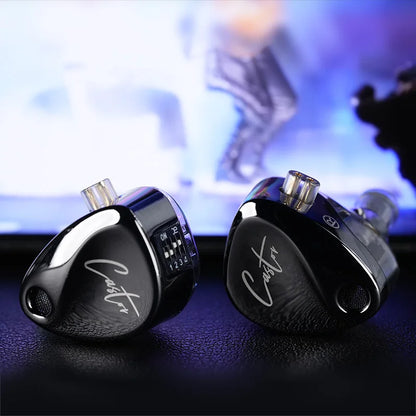 Pair of black earbuds with 'Castor' branding on a blurred background