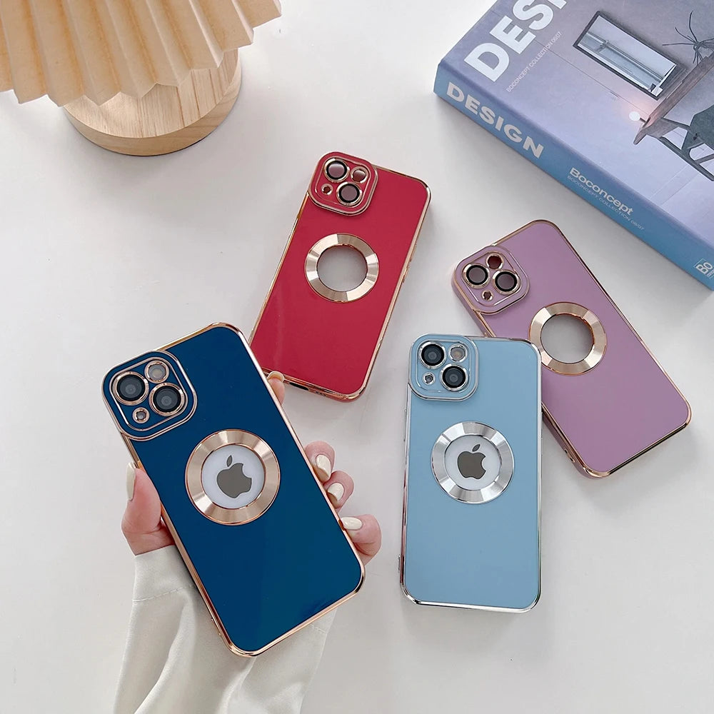 Four phone cases in blue, red, pink, and light blue on a white surface with a book in the background.