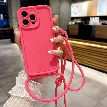 Person holding a pink phone case with a strap in an indoor setting