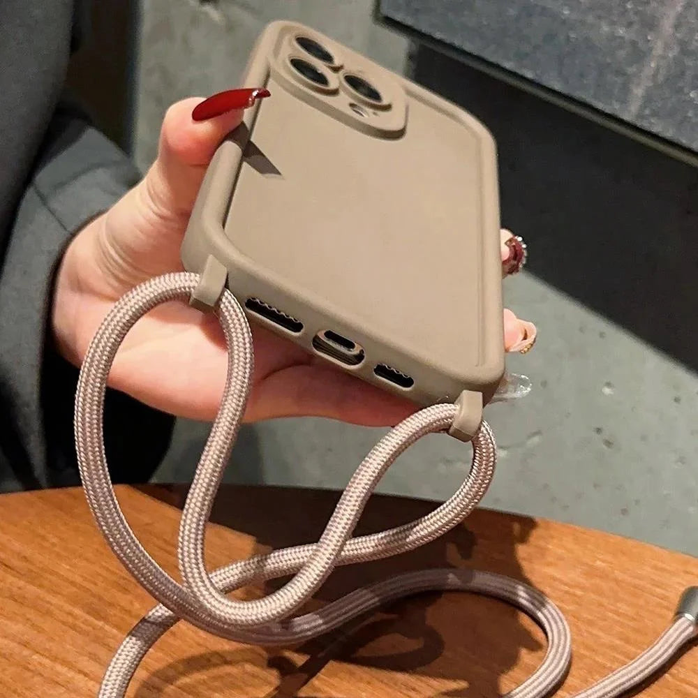 Hand holding a beige phone case with multiple ports and a braided cable, on a wooden surface.