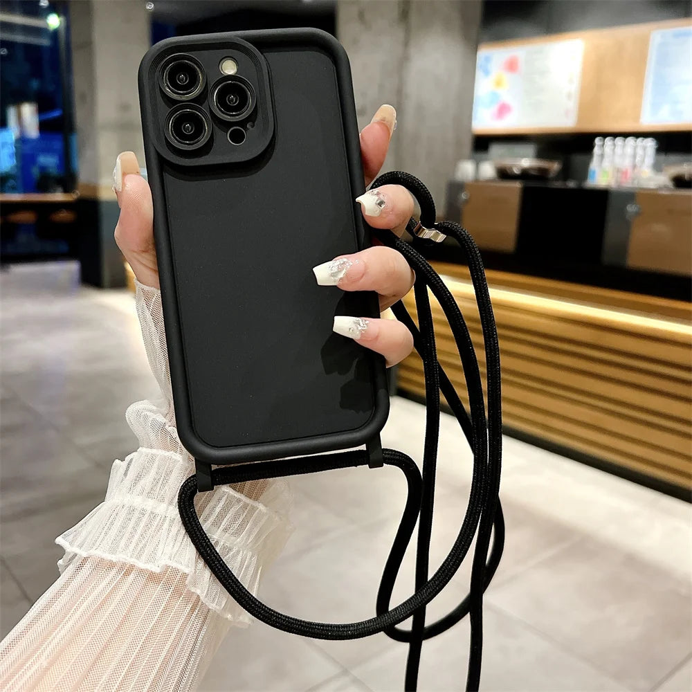 Black phone case with a strap held by a person in an indoor setting