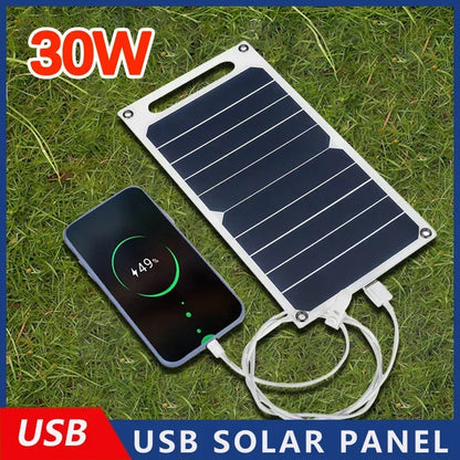 30W USB solar panel charging a smartphone on grass