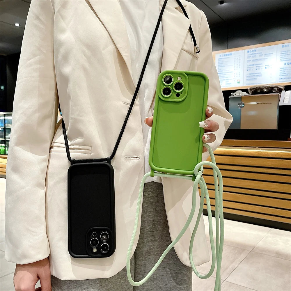 Person holding a green phone case with a black strap in an indoor setting