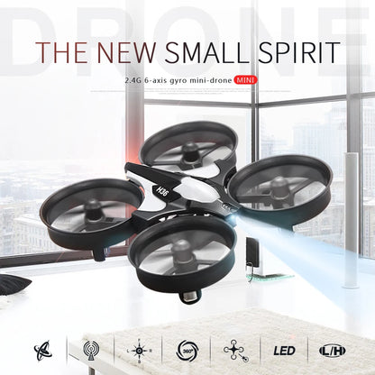 Black mini-drone with transparent propellers on a white surface with a cityscape background