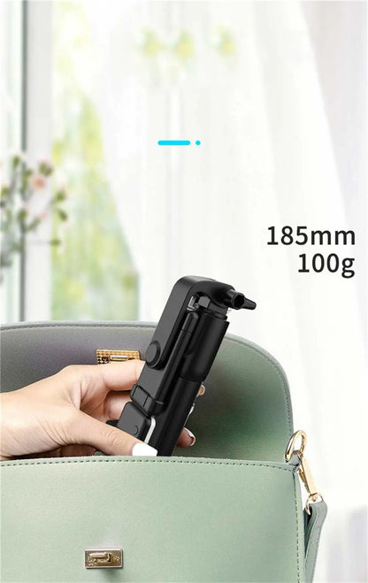 Hand holding a black camera tripod with measurement text on a blurred background