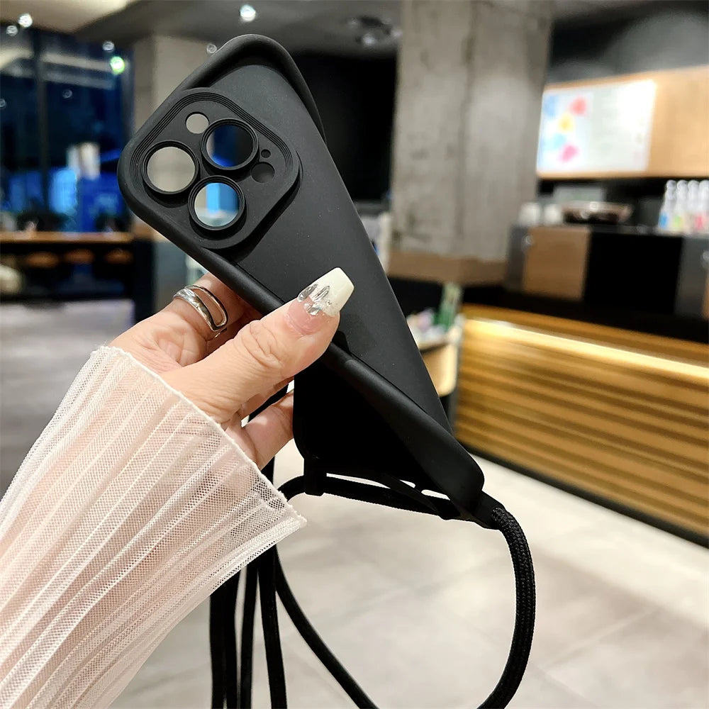 Person holding a black phone case with a blurred indoor background