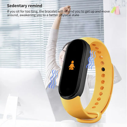 Yellow fitness tracker with black screen worn by a person, against a blurred indoor background.