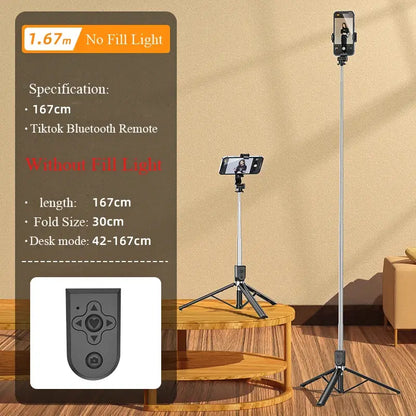 Selfie stick with remote control on a wooden table against a beige wall.
