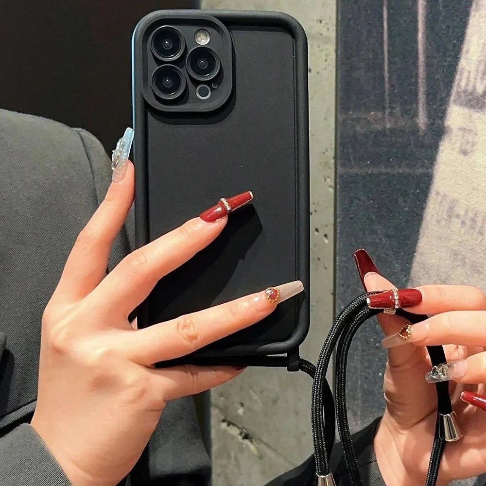 Person holding a black phone case with a reflective surface, showing off red nail polish.
