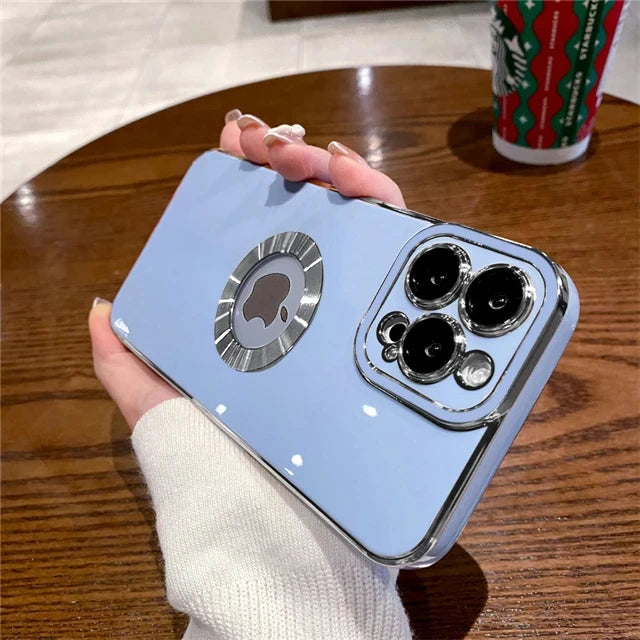 Light blue phone case with camera design held by a hand on a wooden table.