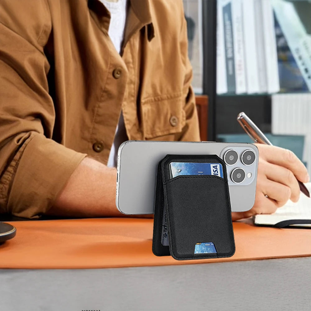 Person using a phone with a card holder attached, sitting at a desk.