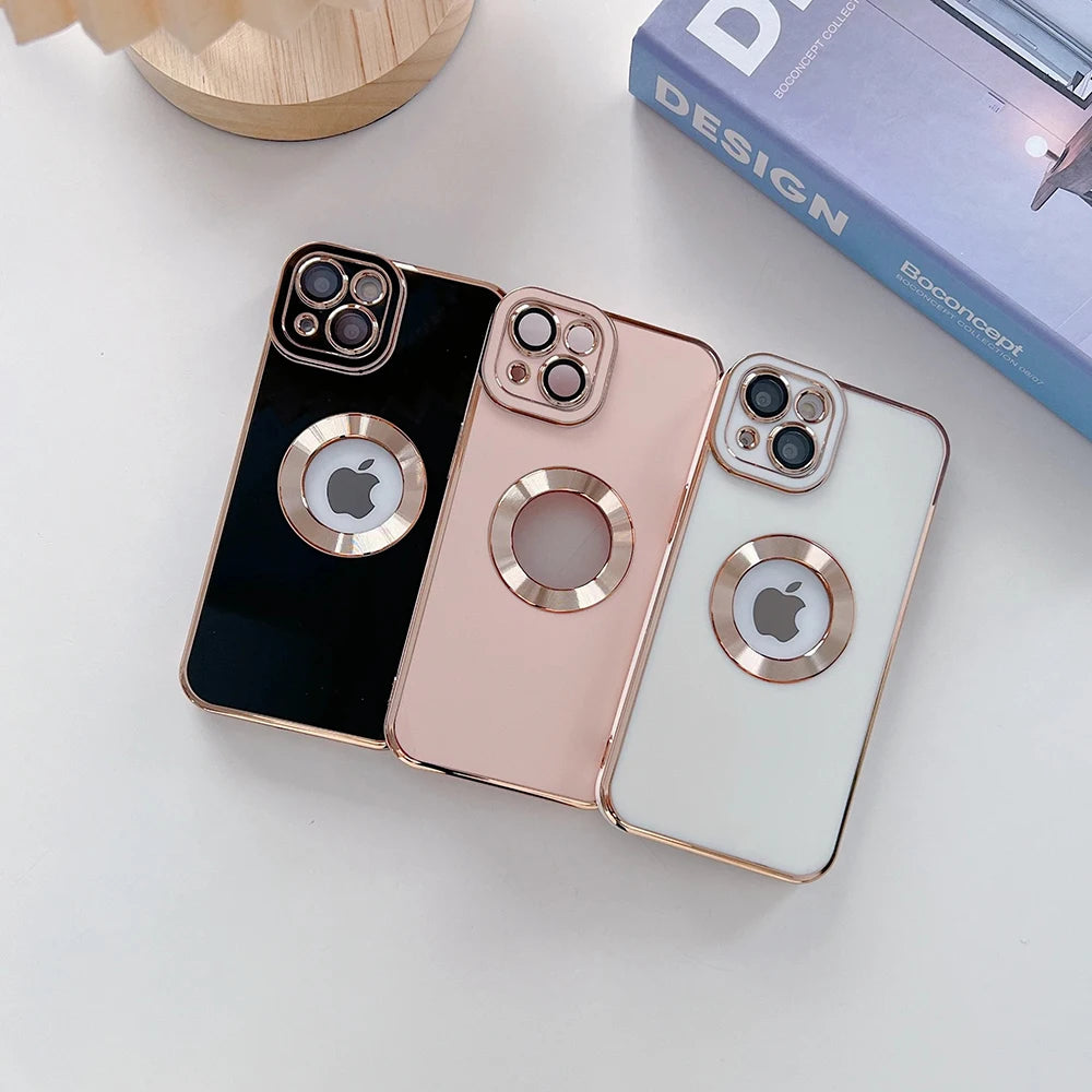 Three phone cases with ring holders on a white surface, one black, one rose gold, and one white.