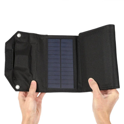 Black solar panel with a textured surface held by two hands against a white background