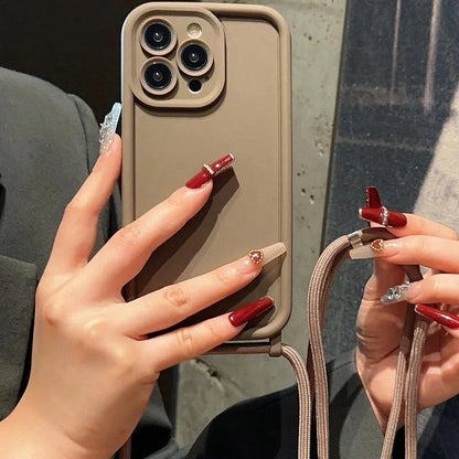 Phone case with a strap held by hands with red nail polish against a dark background