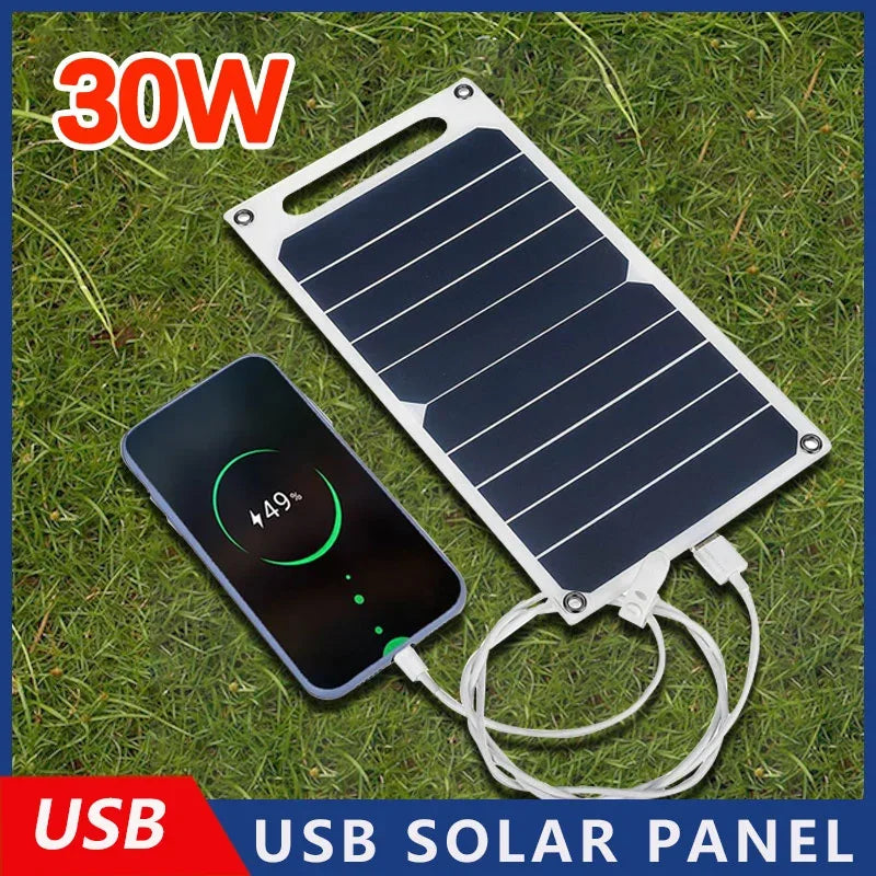 USB solar panel charging a smartphone on grass with '30W' and 'USB' text.