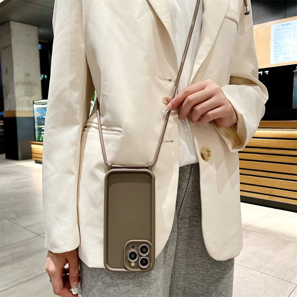 Person wearing a beige blazer with a crossbody phone case in an indoor setting